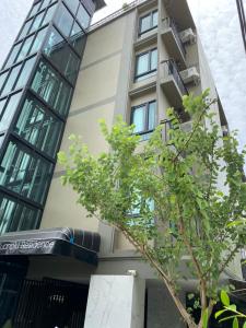 a building with a tree in front of it at 51 Suanplu Residence in Bangkok