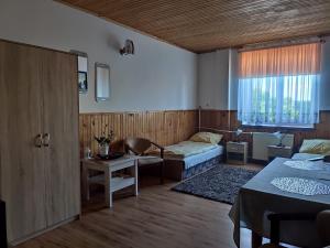 a living room with a bed and a couch in a room at Hotel Kowalski in Mrągowo