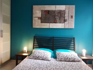 um quarto azul com uma cama com duas velas nas mesas em B&B Brigitte & Alain em Bruxelas