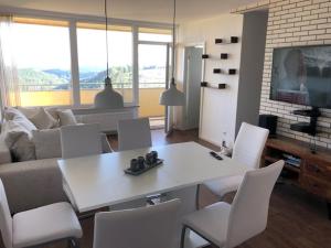 - un salon avec une table et des chaises blanches dans l'établissement App 365 Panoramic Hohegeiß mit WLan, à Braunlage