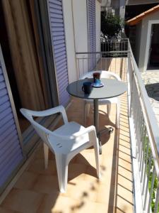 a table and chairs on a balcony with a table at Nidri Studios Apartments in Nydri