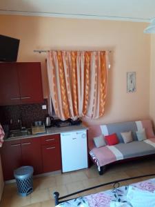 d'une cuisine avec un canapé dans le coin d'une pièce. dans l'établissement Nidri Studios Apartments, à Nydri 2 autres photos