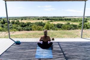 a woman sitting on the floor doing a yoga pose at I Carusi Relais in Noto
