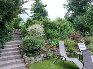 a garden with two chairs and a table and flowers at Ferienwohnung im Westallgäu in Gestratz