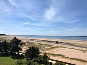 una spiaggia con una persona che cavalca un cavallo sulla sabbia di Appartement "Envies D'ailleurs" Vue Mer a Saint-Brévin-les-Pins