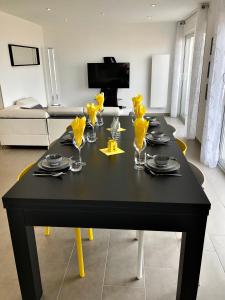 une table noire avec des jambes jaunes dans un salon dans l'établissement Appartement "Envies D'ailleurs" Vue Mer, à Saint-Brévin-les-Pins