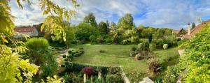 a garden with a large green yard with trees at Beautiful country house located 50min from Paris Eiffel Tour - Demeure d'exception à 50min de Paris Tour Eiffel in Hodent