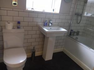 a bathroom with a toilet and a sink and a tub at The Annexe - Acomb Green in York