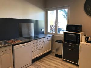 a kitchen with a sink and a microwave at Les Tourterelles in Saint-Aygulf