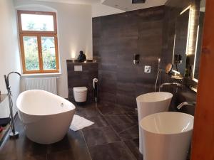 ein Badezimmer mit zwei weißen Badewannen und einem Waschbecken in der Unterkunft Domizil Adler in Dresden