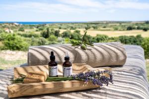 two bottles of wine and a tray with flowers on a couch at I Carusi Relais in Noto