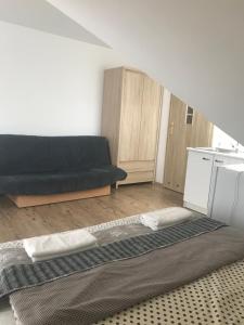 a living room with a black couch and a kitchen at Pokoje gościnne u Izy in Łeba