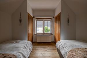 twee bedden in een kamer met een raam bij Niels in Nieuwpoort