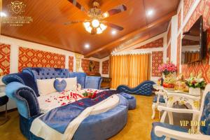 een slaapkamer met een blauw bed en een plafondventilator bij King's Hotel Dịch Vọng in Hanoi