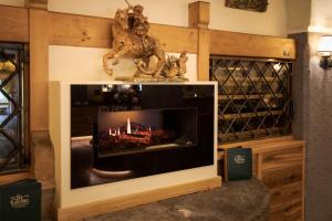 a fireplace in a room with a statue of two cats at Hotel St. Georg in Zell am See