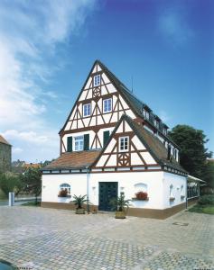 ein großes weißes Gebäude mit einem Gamer-Dach in der Unterkunft Landhotel Altes Wasserwerk GbR in Freinsheim