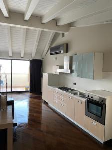 a kitchen with stainless steel appliances and wooden floors at Molino Apartments in Desenzano del Garda
