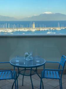 a table with glasses and two chairs on a balcony at Molino Apartments in Desenzano del Garda