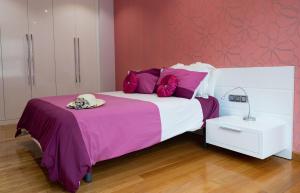 a bedroom with a large bed with purple pillows at Chalet Vilanova in Cee