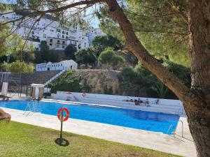 a large swimming pool with people walking around it at Finca Eva 34 Casares Historico in Casares