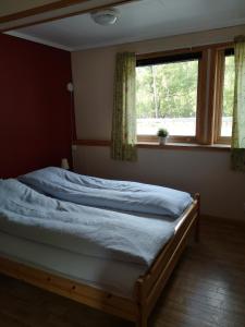 a bed in a bedroom with a window at Kvamsdal Pensjonat in Eidfjord