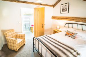 a bedroom with a bed and a chair at Widewath Barn in Penrith