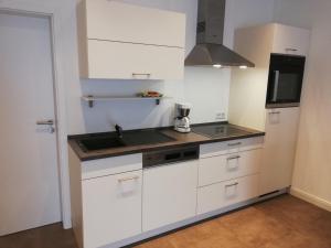 a kitchen with white cabinets and a sink at Wein Ferienhaus Kerner in Lieser