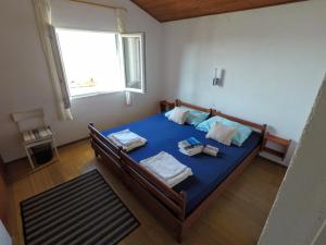 1 dormitorio con cama con sábanas azules y ventana en Apartment Gašparević, en Rogoznica