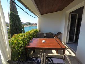 una mesa y sillas en un balcón con vistas al agua en Apartment Gašparević, en Rogoznica