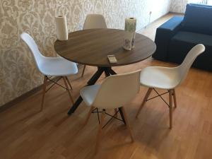 a table with four white chairs and a blue couch at Ekaterina Appartment 2 in Odesa