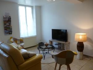 HOME VACANCES 4 étoiles par CDT DORDOGNE في Le Pizou: غرفة معيشة مع أريكة وتلفزيون
