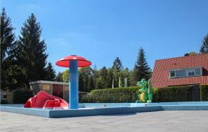 een speeltuin met een rode paraplu en een speeluitrusting bij Awesome Home In Vorden With 3 Bedrooms And Wifi in Vorden