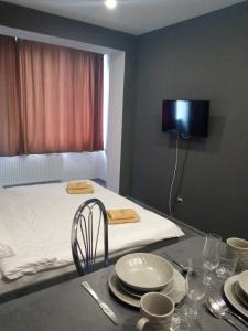 una camera con un letto e un tavolo con piatti di Новая и уютная квартира в центре a Užhorod