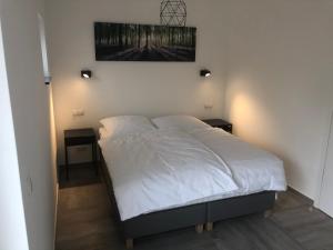 1 dormitorio con 1 cama blanca y 2 mesitas de noche en Kruft-apps, en Kruft