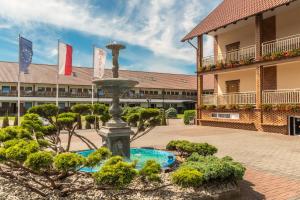 a fountain in a courtyard in front of a building at Baron in Sztutowo