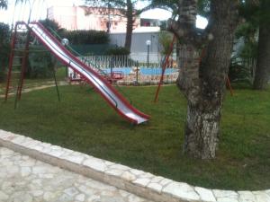 a slide in a park next to a tree at Bed and Breakfast Fly in Bari