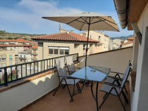 a table and chairs on a balcony with an umbrella at APARTAMENTO QUINTO in Valderrobres
