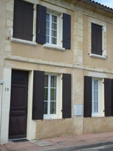 Un edificio con persianas negras en el costado. en HOME VACANCES 4 étoiles par CDT DORDOGNE, en Le Pizou
