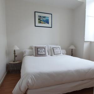 una camera con un letto bianco con due cuscini di Escale dinannaise a Dinan