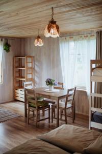 Saka的住宿－Kempings Ievlejas，一间带木桌和椅子的用餐室