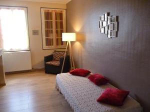 Un dormitorio con una cama, una silla y una lámpara. en HOME VACANCES 4 étoiles par CDT DORDOGNE, en Le Pizou