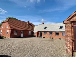 zwei Backsteingebäude mit einer Auffahrt vor ihnen in der Unterkunft Hennebjerg overnatning in Stavsø