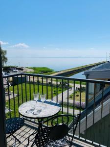 a balcony with a table with two wine glasses on it at Lagoon Attic Apartment Pervalka in Pervalka