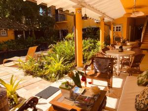 un patio al aire libre con mesas, sillas y una mesa en Villa Paradiso Pousada, en Camburi