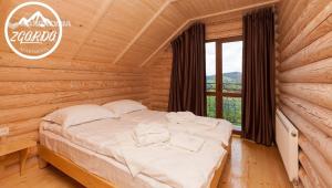 - une chambre avec un lit dans une cabane en rondins dans l'établissement Zgarda, à Vorokhta