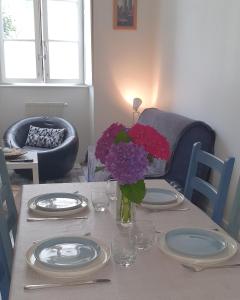 un tavolo con piatti e un vaso di fiori sopra di Escale dinannaise a Dinan