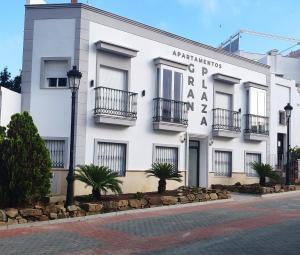 a white building with a sign on the side of it at Apartamentos Gran Plaza De Nerja in Nerja
