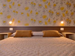 a bedroom with a bed with yellow flowers on the wall at IL NIDO L'Aquila in LʼAquila