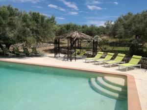 a group of chairs and a gazebo next to a pool at Casa El Dragonet in Perelló