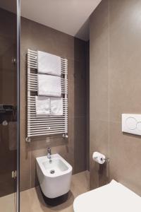a bathroom with a sink and a toilet and towels at Hotel Aquarius Venice - Ascend Collection in Venice